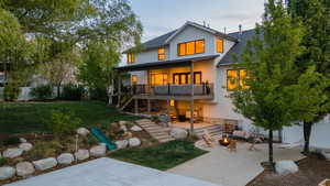 Rear view of house featuring a patio, a shingled roof, and stucco siding