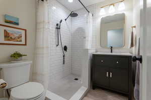 Full bath featuring vanity, a stall shower, and light tile patterned flooring