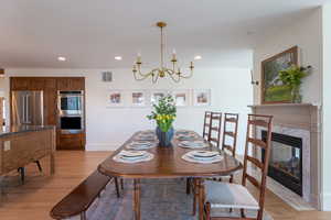 Dining room featuring light wood-type flooring, a high end fireplace, and suspended lighting