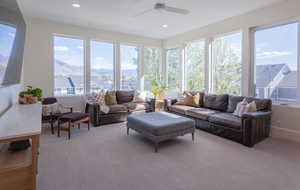 Living room with a mountain view, light carpet, ceiling fan, and recessed lighting