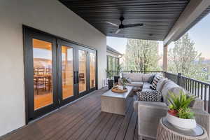 Wooden terrace with french doors, ceiling fan, and an outdoor hangout area