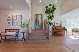 Stairs featuring wood finished floors and recessed lighting