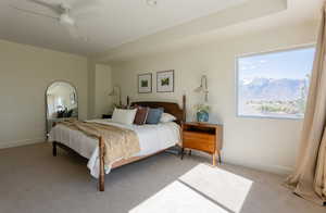 Bedroom featuring light colored carpet, a ceiling fan, and a mountain view