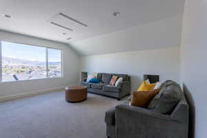 Living room with a mountain view, vaulted ceiling, and carpet flooring