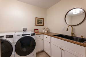 Laundry room with cabinet space, independent washer and dryer, and light tile patterned flooring