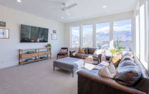 Carpeted living room featuring a ceiling fan and recessed lighting