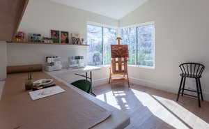 Office area featuring vaulted ceiling and light wood-style flooring
