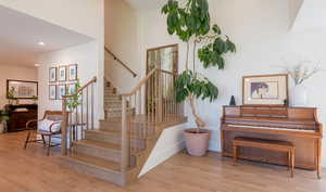 Staircase featuring wood finished floors and recessed lighting
