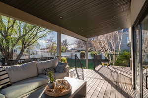 Wooden terrace featuring a fenced backyard and outdoor lounge area