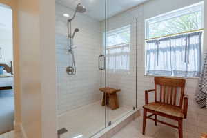 Full bath with a stall shower and connected bathroom