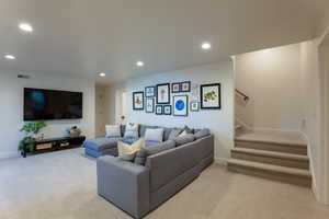 Living area with recessed lighting and light carpet