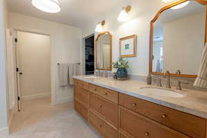 Full bathroom featuring double vanity and baseboards