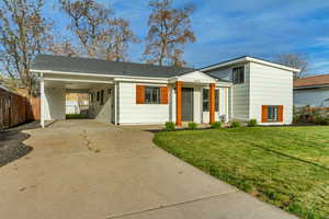 View of front of home featuring driveway and an attached carport
