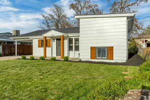Back of property featuring an attached carport and roof with shingles