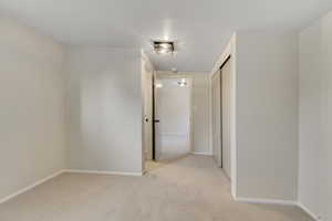 Bedroom with light carpet and baseboards