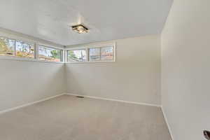 Empty room with baseboards and light carpet