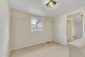 Spare room with light carpet and baseboards