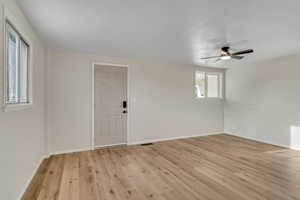Empty room with light wood-style flooring and a ceiling fan