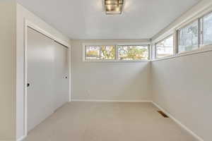 Unfurnished bedroom featuring light carpet and a closet