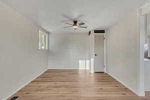 Unfurnished room with a ceiling fan and light wood-type flooring