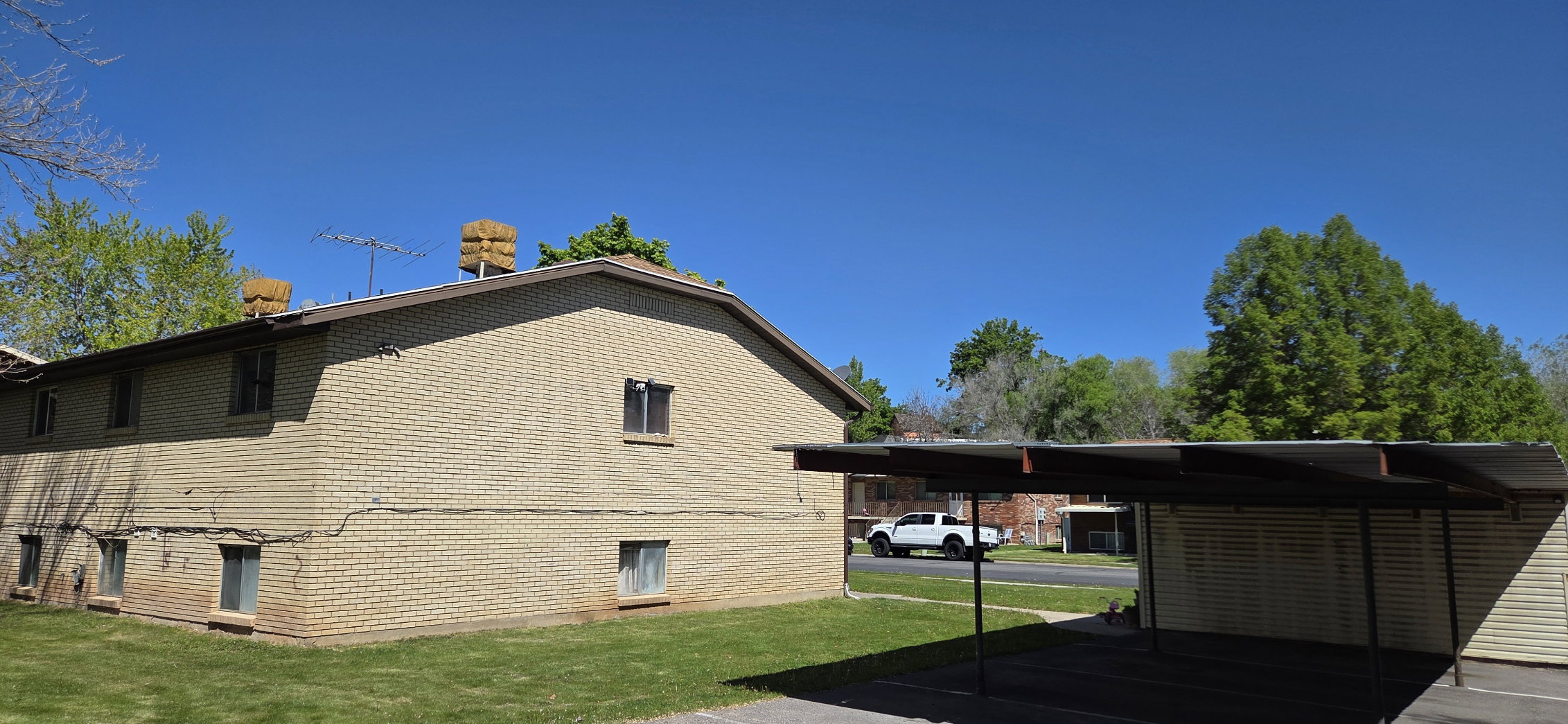View of side of property featuring a yard and brick siding
