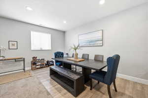 Dining room with light wood-style floors and recessed lighting