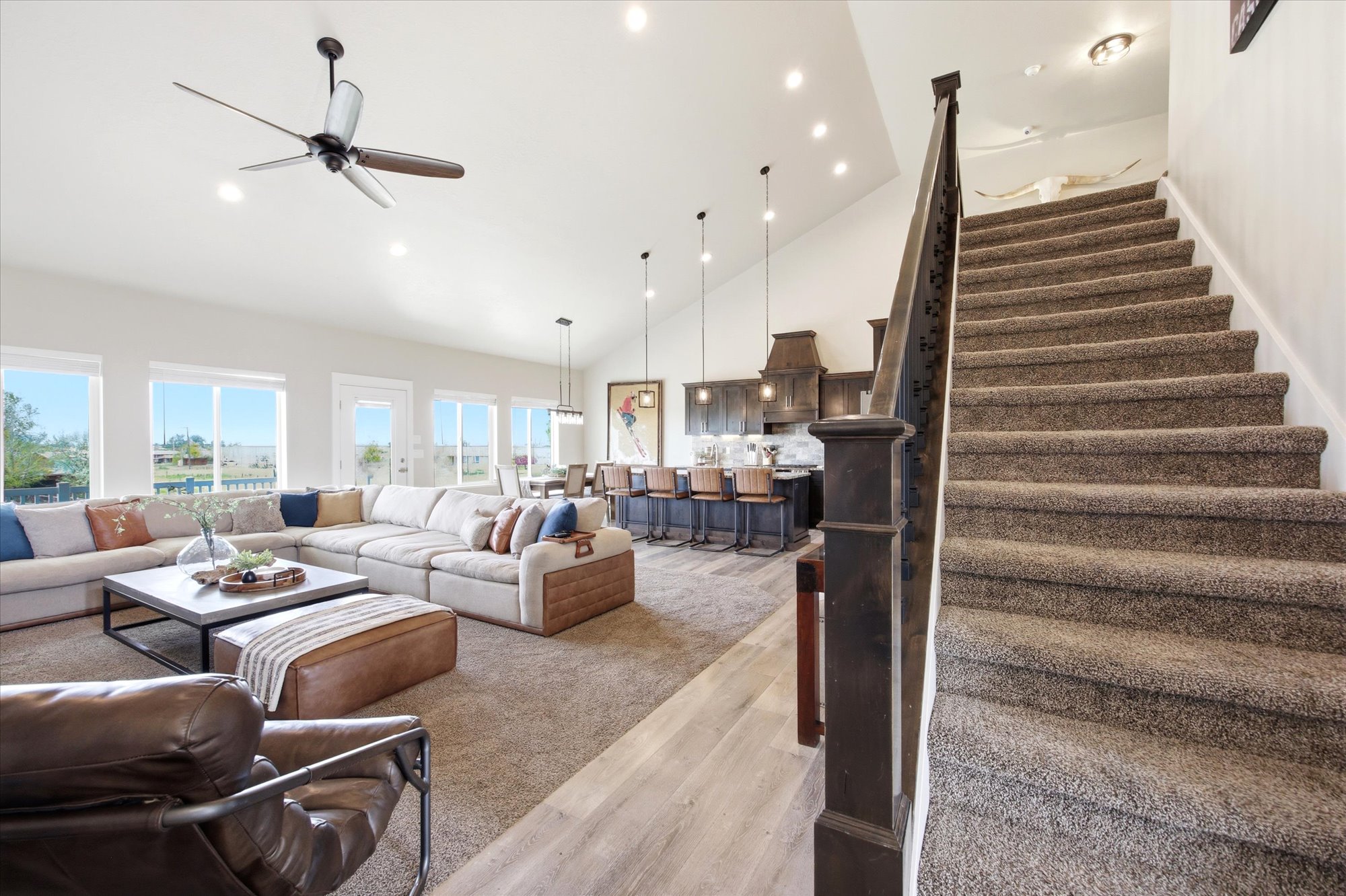 Living room featuring light wood-type flooring, ceiling fan, light carpet, recessed lighting, and lofted ceiling