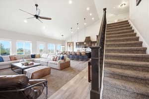 Living room featuring light wood-type flooring, ceiling fan, light carpet, recessed lighting, and lofted ceiling