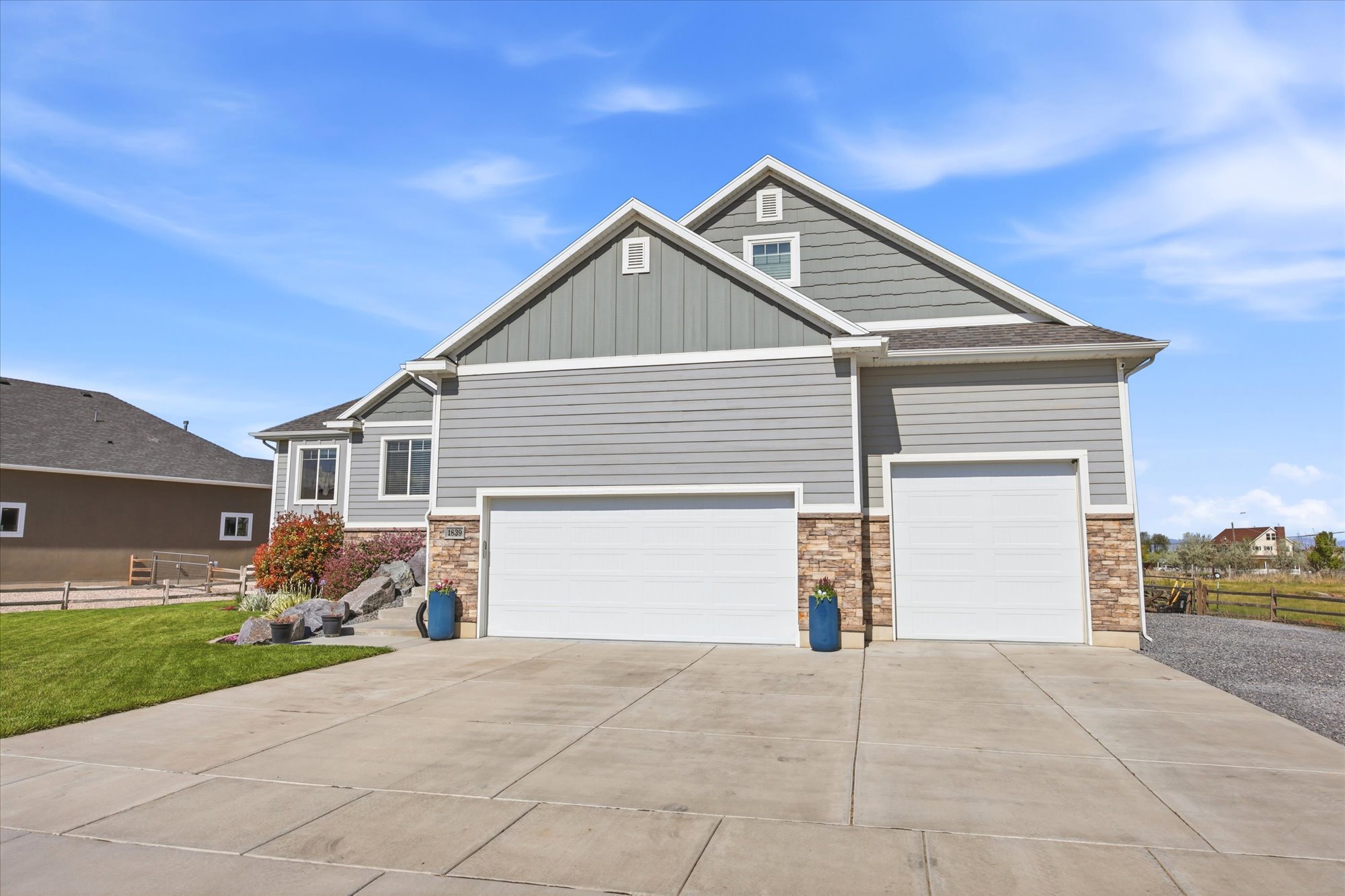 Craftsman-style home with board and batten siding, stone siding, concrete driveway, an attached garage, and a garage