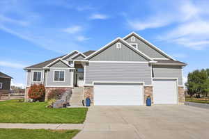 Craftsman house with board and batten siding, stone siding, concrete driveway, and a garage
