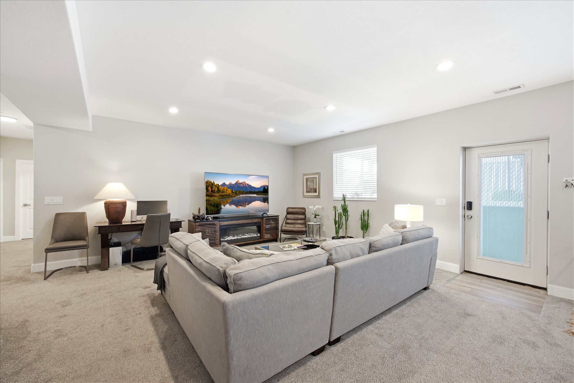 Living area with light carpet and recessed lighting