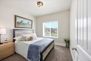 Bedroom with dark colored carpet and baseboards