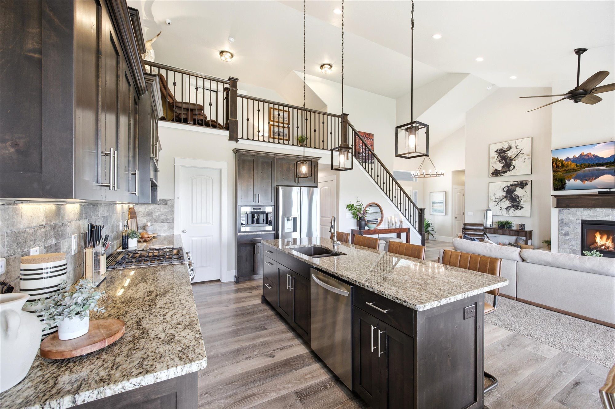 Kitchen with dark wood finish cabinetry, a kitchen breakfast bar, light stone counters, open floor plan, and an island with sink