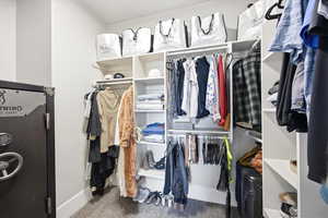 Walk in closet with dark colored carpet