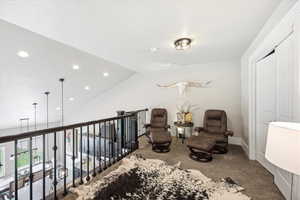 Living area with vaulted ceiling, carpet flooring, and recessed lighting