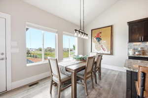 Dining room with vaulted ceiling and light wood-style floors