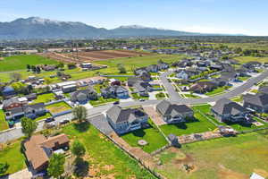 Aerial view of property and surrounding area featuring mountains and nearby suburban area