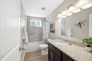 Full bathroom featuring vanity, shower / bath combo with shower curtain, and dark wood-style floors