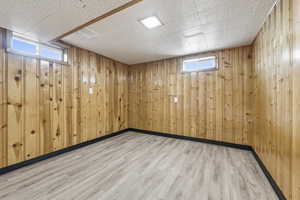 Basement featuring wood finished floors and wood walls