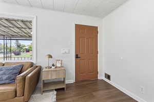 Entrance foyer with dark wood-style flooring and crown molding
