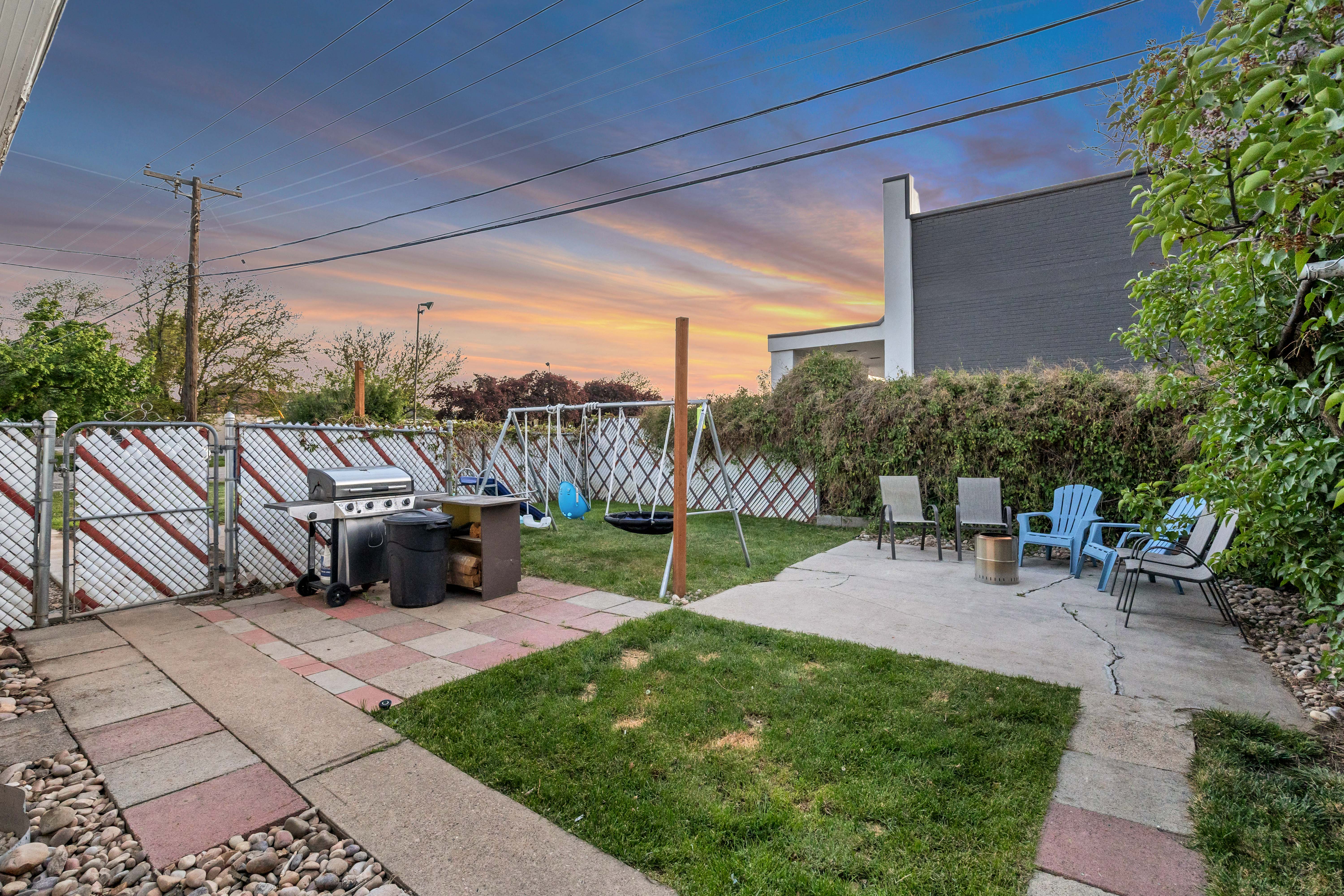 Yard at dusk with a patio, a gate, and a fenced backyard