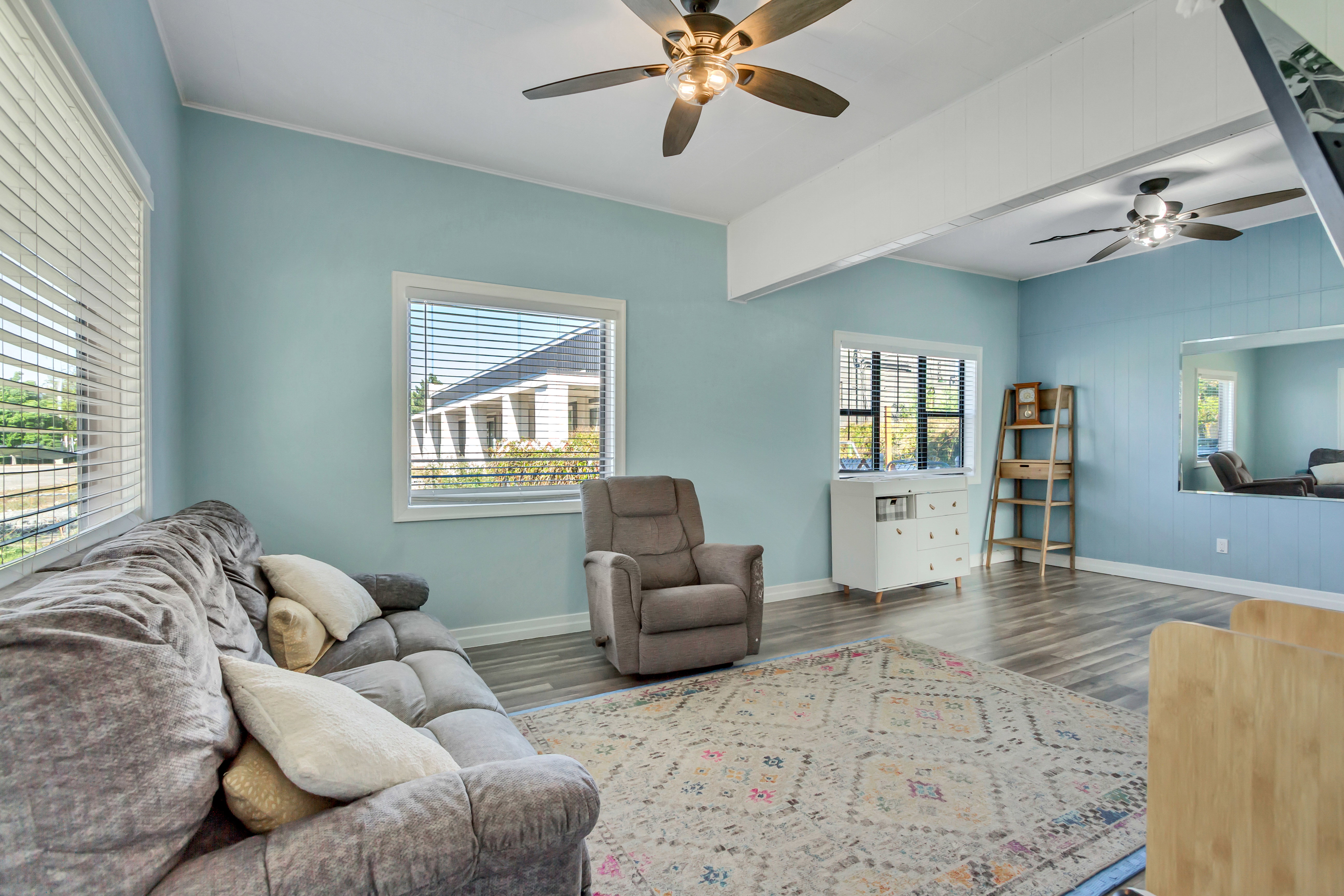 Living area with a ceiling fan and dark wood-style floors