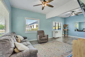 Living area with a ceiling fan and dark wood-style floors