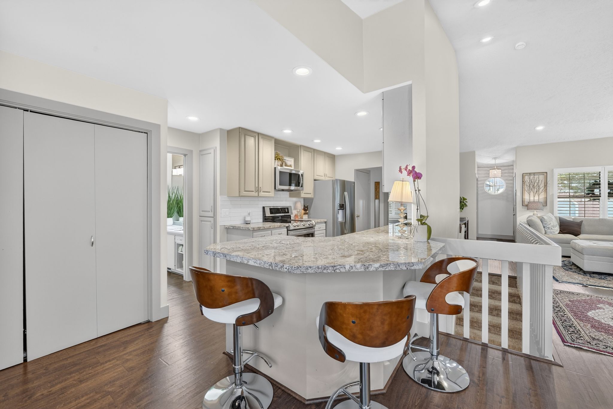 Kitchen with a breakfast bar, stainless steel appliances, open floor plan, dark wood finished floors, and recessed lighting