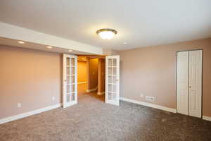 Unfurnished bedroom with french doors, carpet, recessed lighting, and a closet
