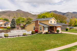 View of front of house featuring a mountain view, driveway, brick siding, and covered porch