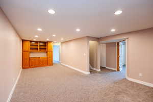 Empty room with recessed lighting and light colored carpet
