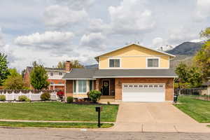 Traditional-style house with driveway, an attached garage, a shingled roof, and brick siding