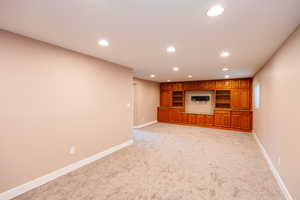 Unfurnished living room featuring recessed lighting and light carpet