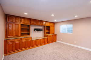 Unfurnished living room with carpet flooring and recessed lighting